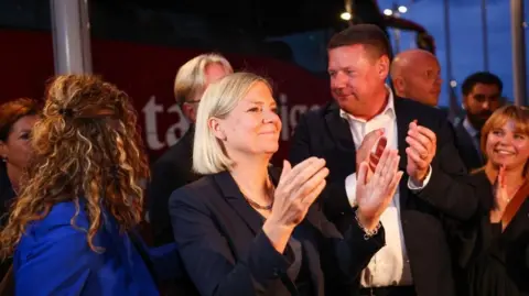 Reuters Sweden's Social Democratic Party leader, Magdalena Andersson applauds as she waits with other party members for general election results