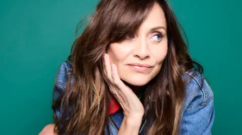Rankin Promotional photograph of Natalie Imbruglia in a denim jacket, with her head resting in her right hand