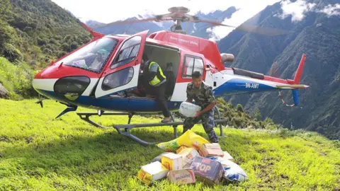 PRABIN RANABHAT / AFP via Getty Images A Nepal Armed Police Force personnel unloads relief supplies from a helicopter for flood affected people in Nepal's Rasuwa district on September 1, 2026.