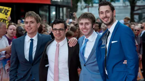 Getty Images Simon Bird, Joe Thomas, James Buckley and Blake Harrison pose for photos at the world premiere of The Inbetweeners 2. The group are all wearing suits with skinny ties. 