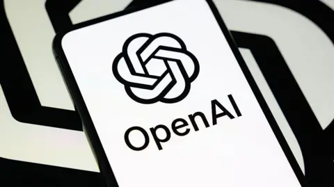 Getty Images OpenAI's logo in black and white on a phone against a black and white spiral backdrop like its logo