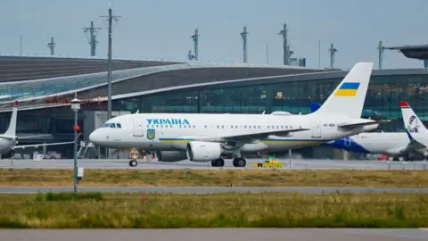 Reuters A white painted passenger plane sits on a runway at an airport after landing