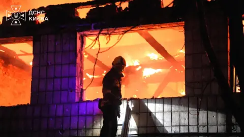 DSNS / Kyiv A firefighter tackles a fire in a building after overnight Russian strikes on Ukraine's capital Kyiv. Photo: 1 September 2026