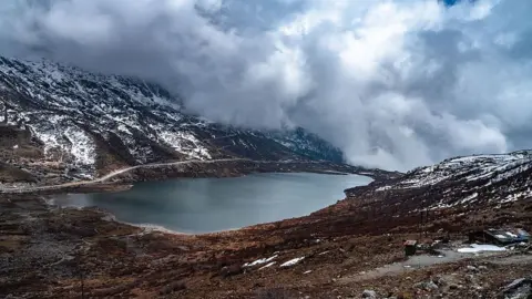 Nur Photo via Getty Images Kupup Lake, also known as Bitan Cho or Elephant Lake, is a high-altitude glacial lake near Jelep La Pass in East Sikkim, India, on April 17, 2026. The lake, situated at approximately 13,066 feet, is part of the Old Silk Route loop near the India-China border and is often frozen from winter through mid-May. I