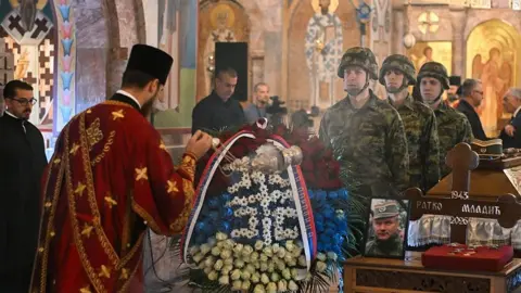Getty Images An Orthodox priest blesses the coffin of late Bosnian Serb military leader Ratko Mladic during a public memorial on the day of his funeral ceremony at St Lukas church in Belgrade, on September 7, 2026
