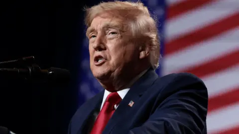 Reuters U.S. President Donald Trump delivers remarks at Red Rock Casino Resort Spa in Las Vegas, Nevada, U.S., August 5, 2026. It is a head-and-shoulders shot and he is wearing a blue jacket and shiny red tie. 