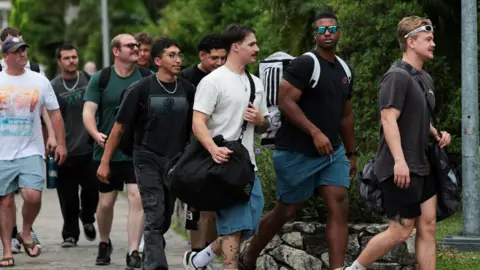 Reuters US sailors, in civilian clothing, walk outside a hotel.