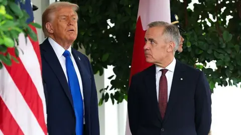 Getty Images US President Donald Trump speaks to Canadian Prime Minister Mark Carney  during a welcome outside the West Wing of the White House in October 2025