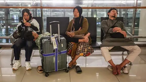 Getty Images Stranded passengers rest on a bench at Soekarno-Hatta Airport in Tangerang on September 6, 2026